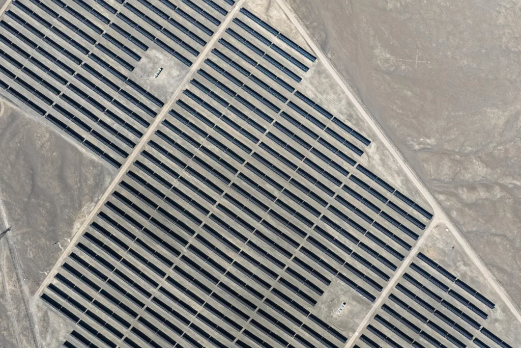 Aerial view of a large solar plant with long rows of solar panels arranged in a grid pattern across a barren desert landscape Solar panel